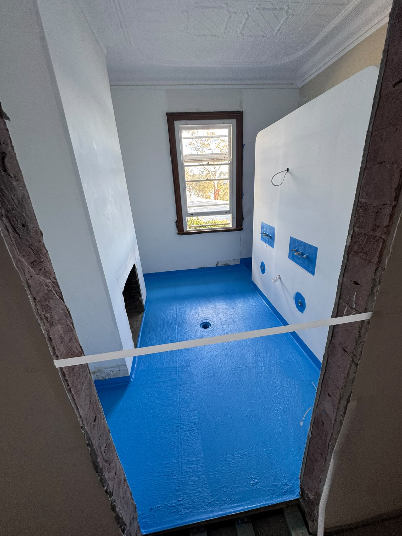 Bathroom sealed with a blue waterproofing membrane
